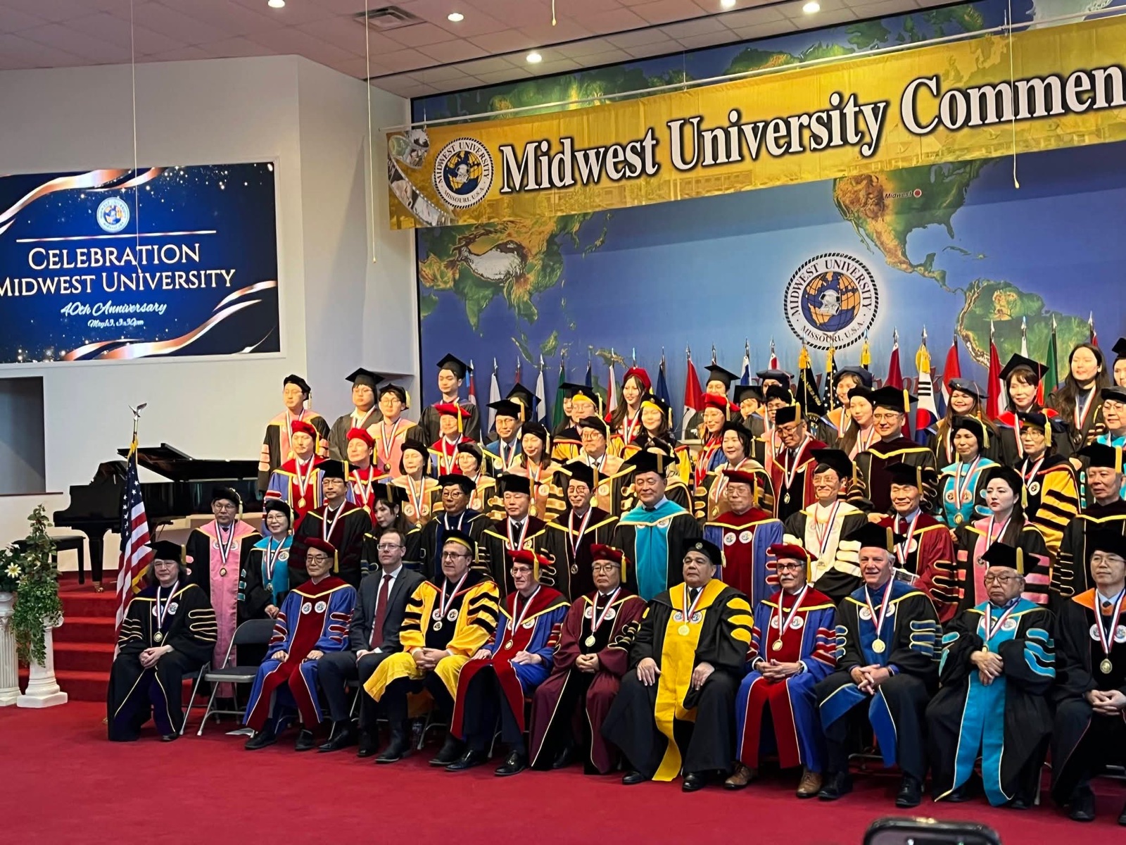 The commencement stage, with the banner for the university’s 40th anniversary at left and the graduating class assembled